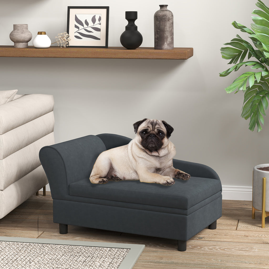 Pug dog sitting on a gray pet bed in a living room setting with a shelf and plant in the background.