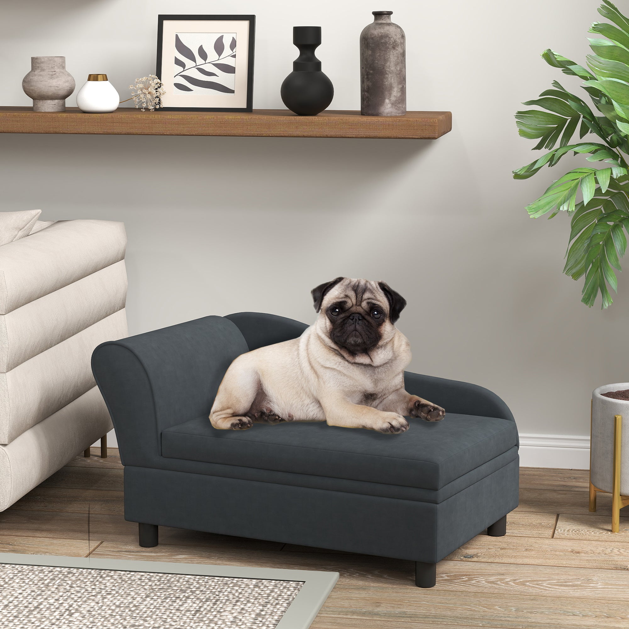 Pug dog sitting on a gray pet bed in a living room setting with a shelf and plant in the background.